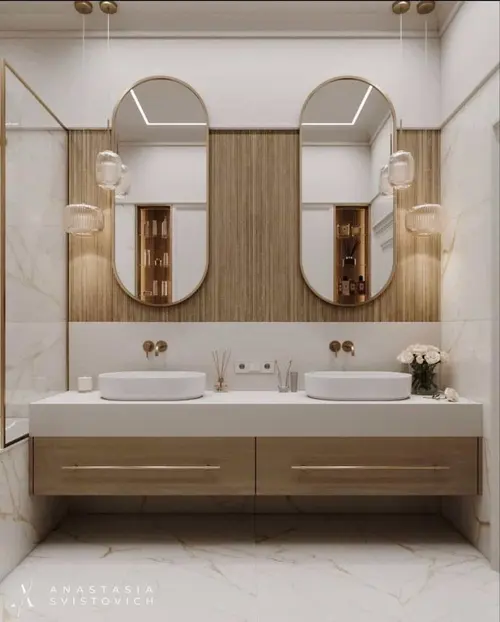 Two arched mirrors on a fluted timber panel above a white vanity with a pair of round basins, ribbed glass pendants either side